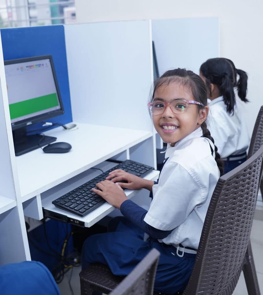 Smiling student using a computer in the lab at Infinity World School — a top CBSE school in Chanda Nagar focused on digital learning.